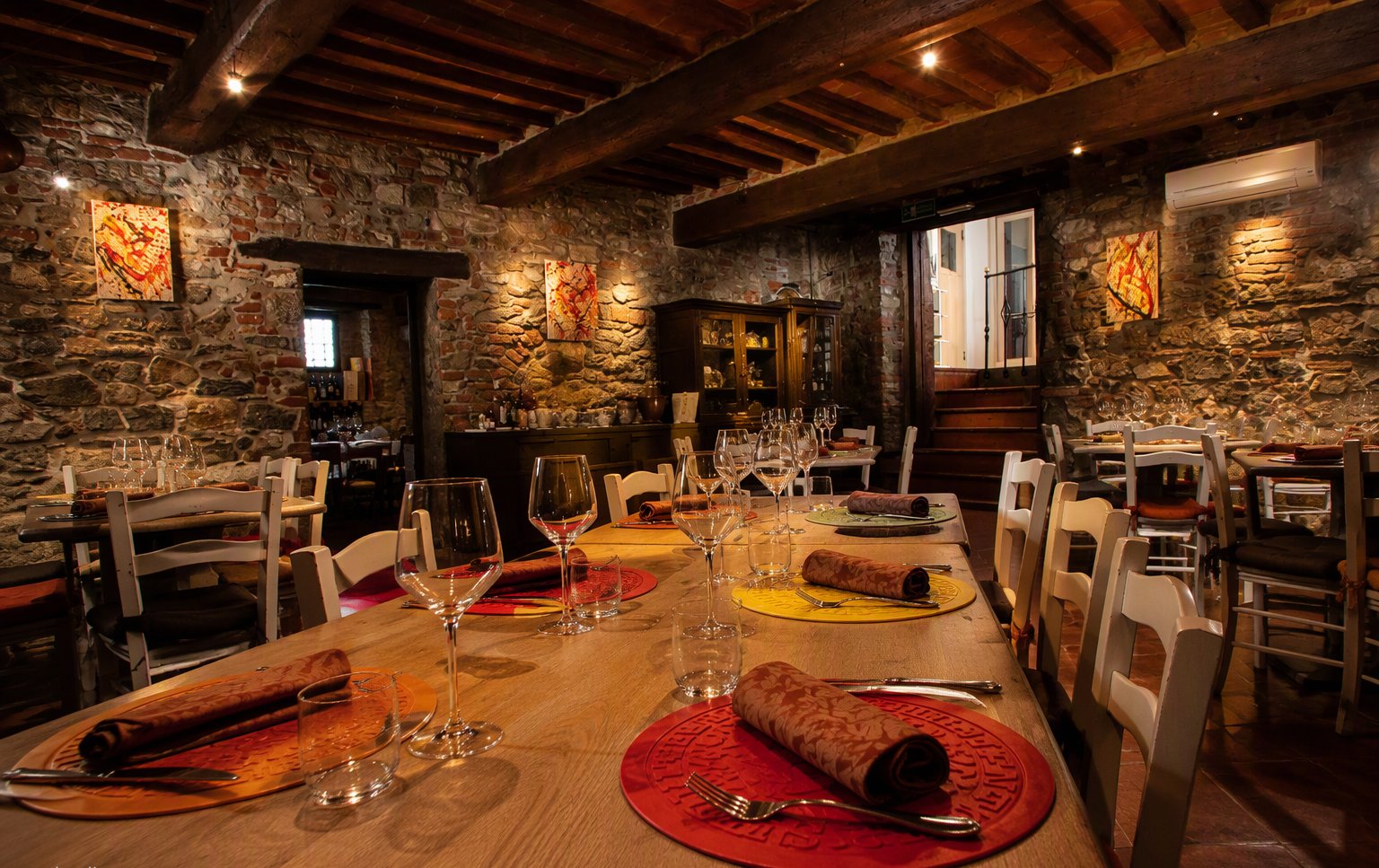 La sala grande in pietra e travi di legno con la tavola apparecchiata